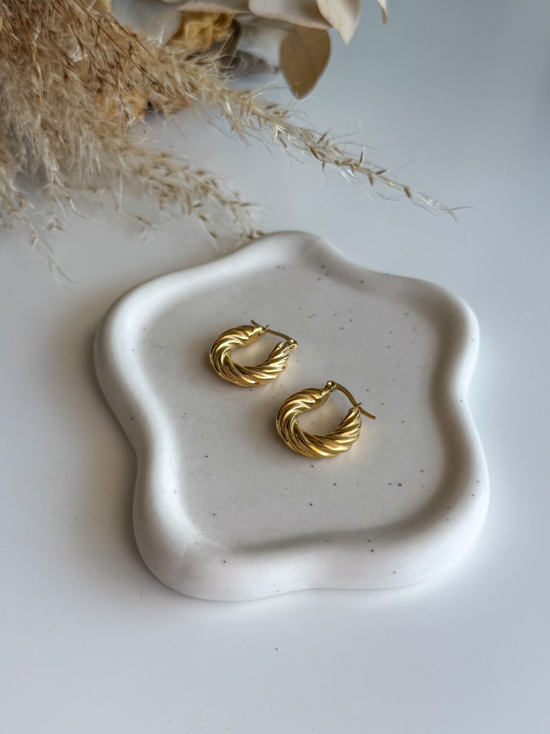 χρυσά κρικάκια με στριφογυριστό σχέδιο